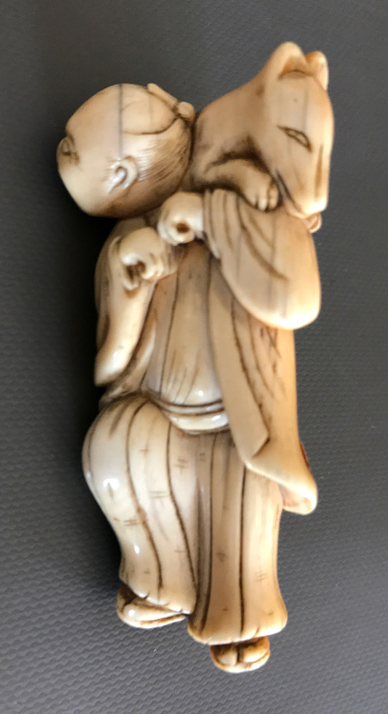 Ivory netsuke of a man dancing with a fox on his shoulder