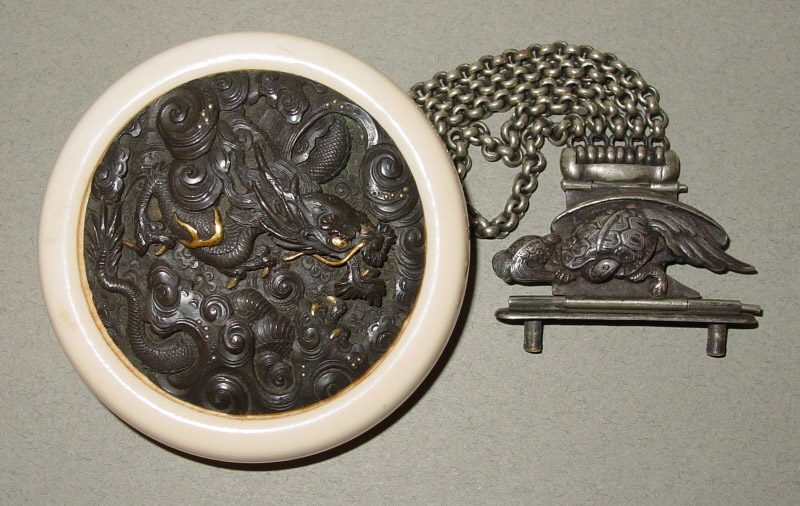 Kagamibuta netsuke with silver dragon plate, silver chain and clasp of a minogame